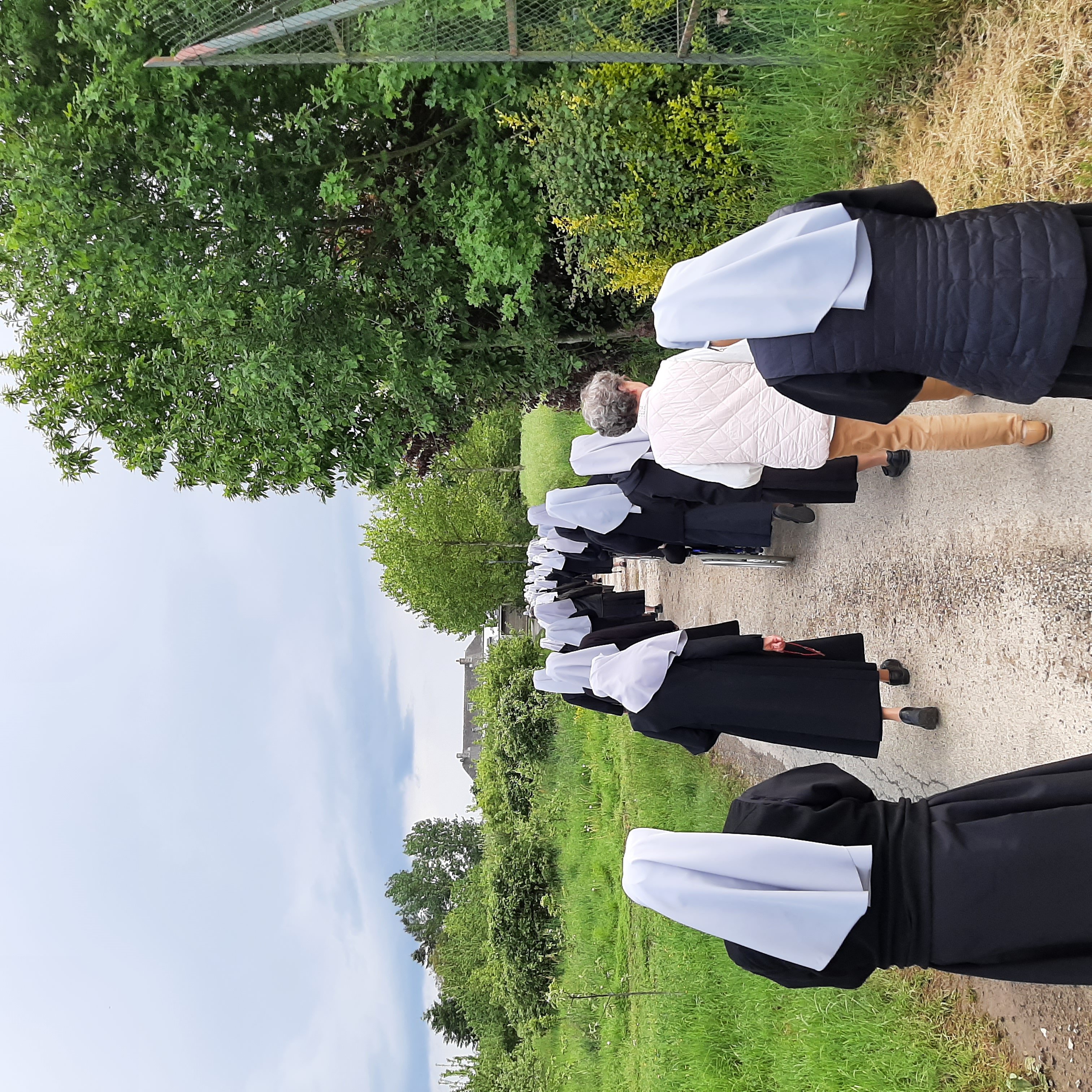 Petites sœurs et civils qui marchent en procession
