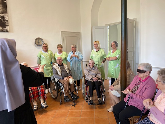 Personnes âgées et Petites Sœurs assis dans une pièce