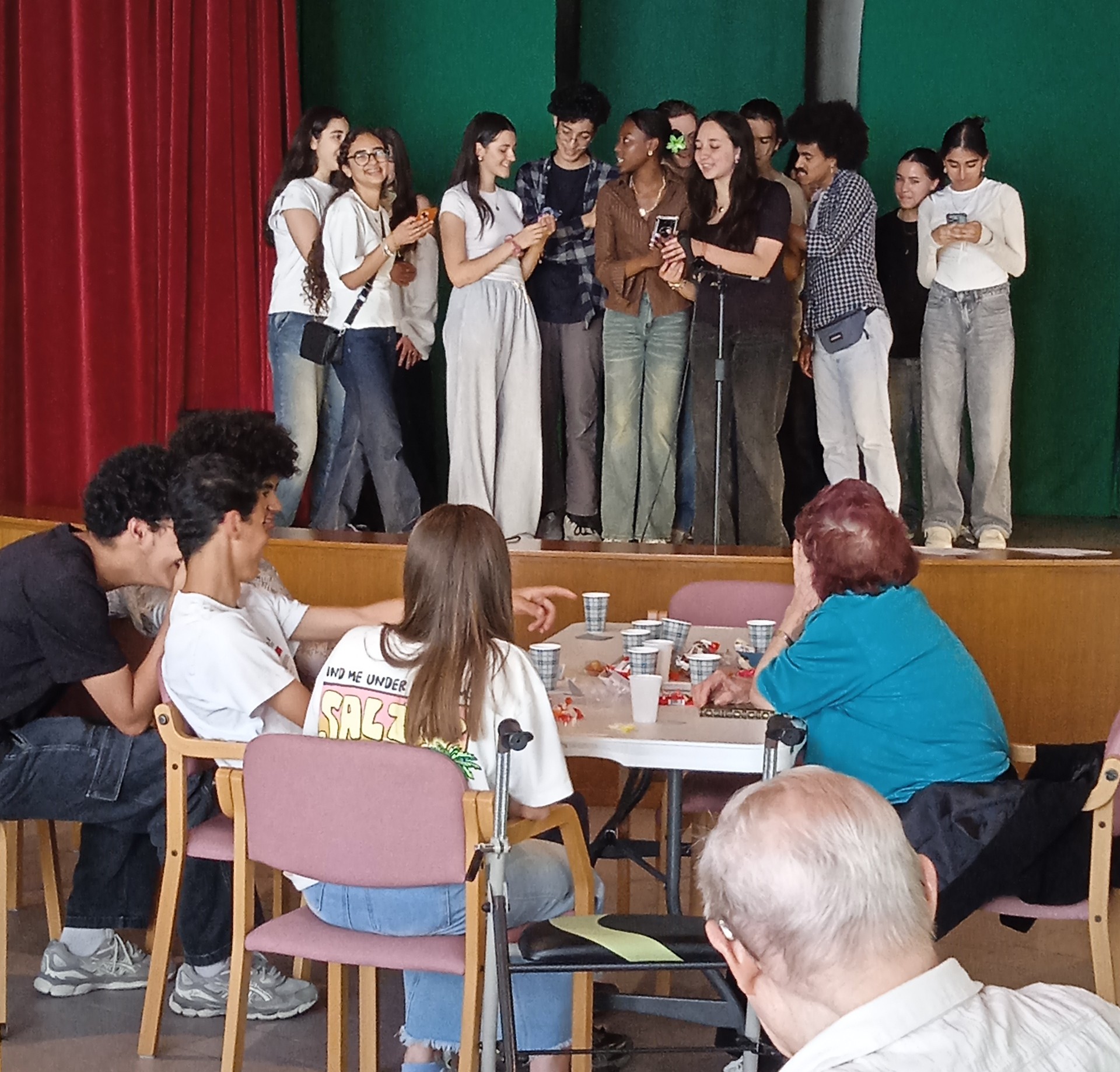 Ado qui chantent sur une scène devant des personnes âgées