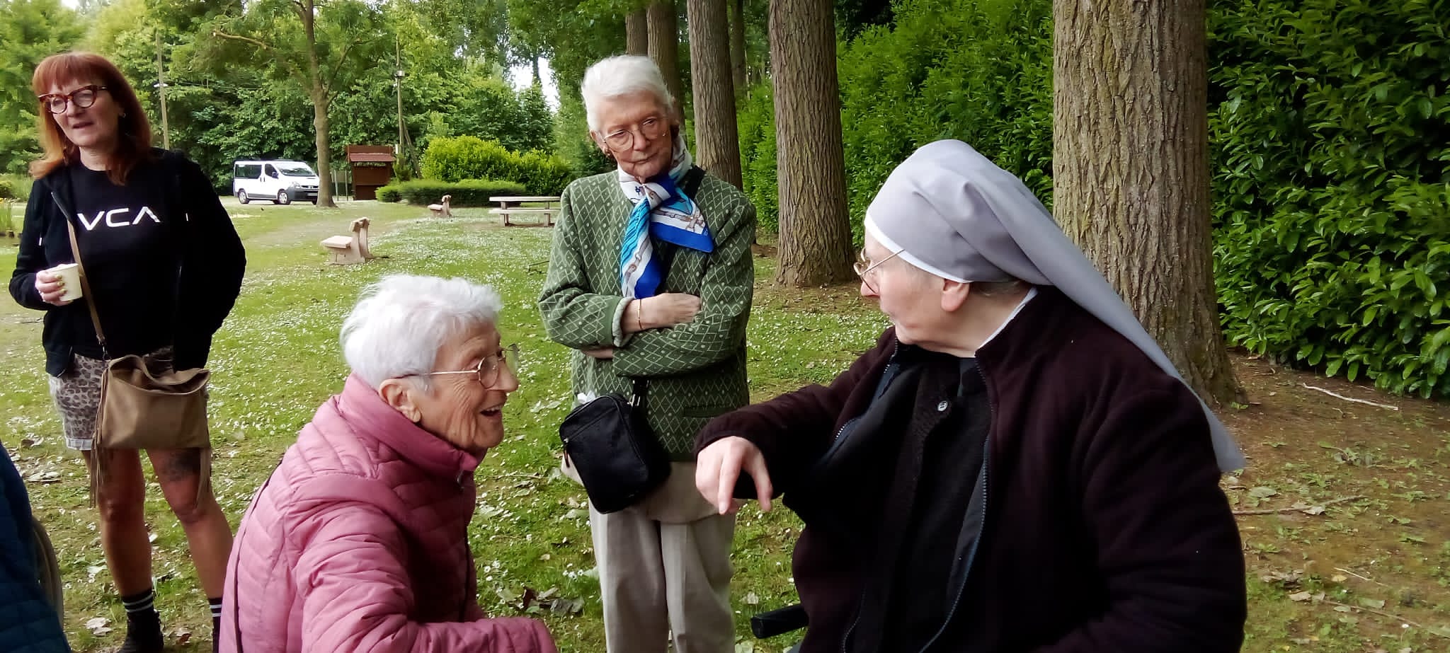 Petite Sœur qui discute avec une personne âgée dans un parc