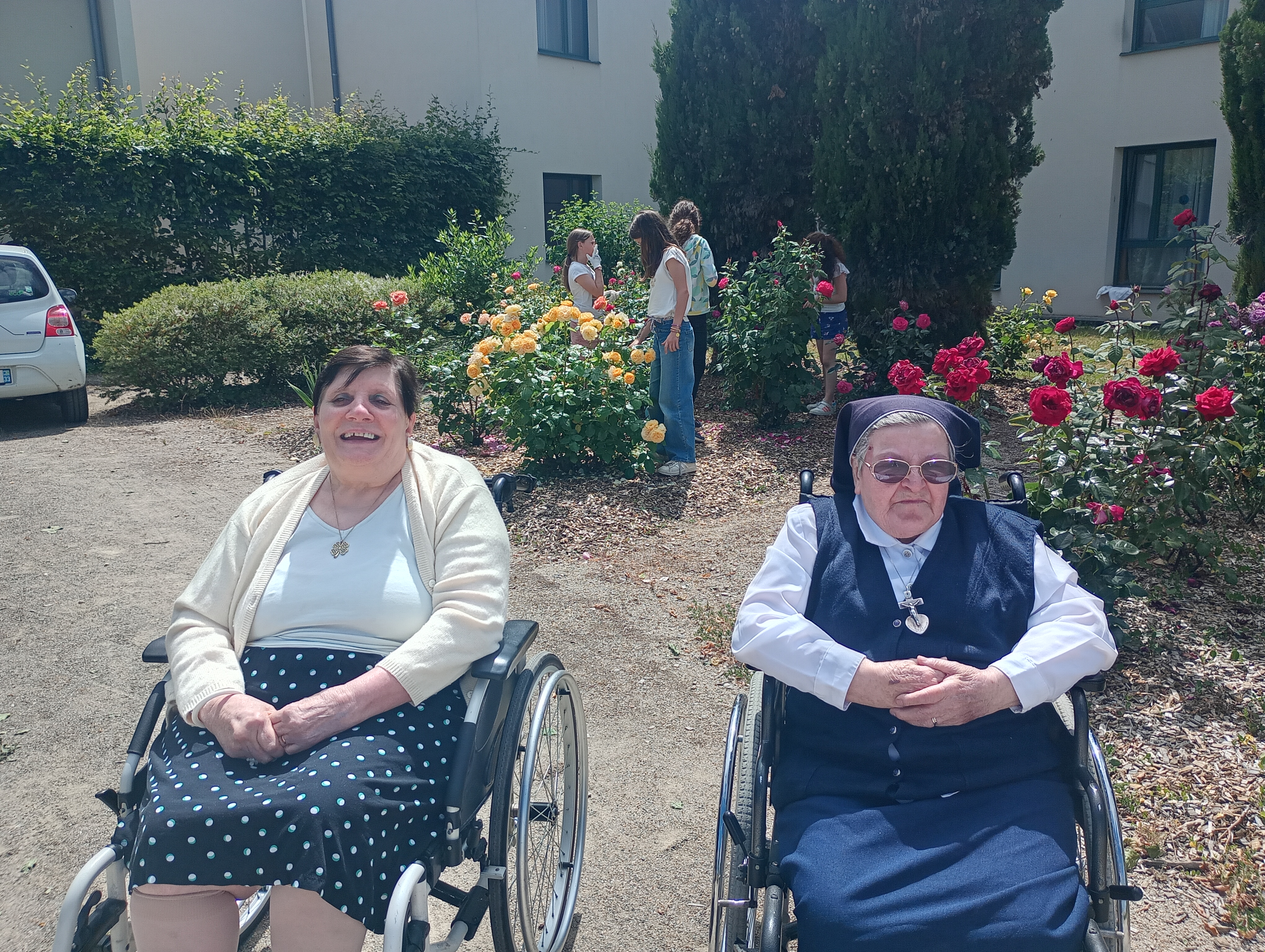 2 personnes âgées dans un fauteuil roulant dans un jardin