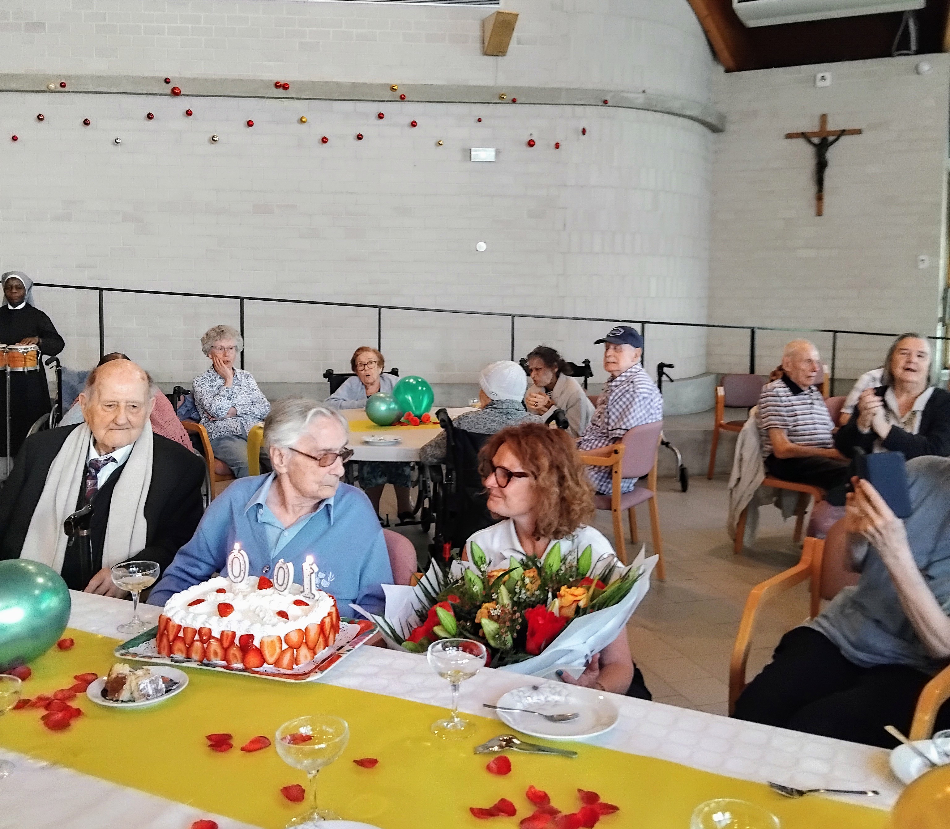 Grande fête dans un ehpad avec des personnes âgées assises devant un gâteau