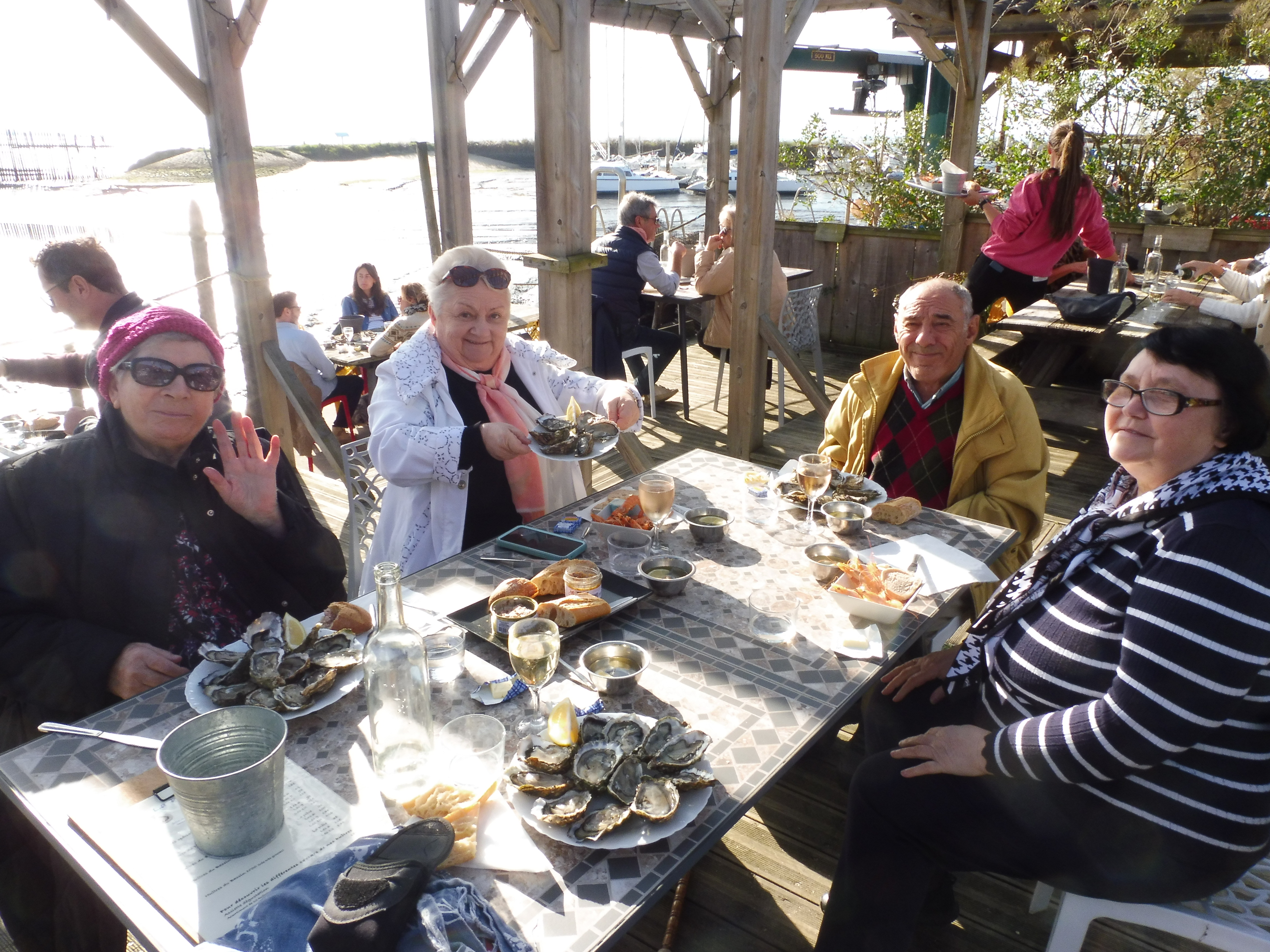 Personnes âgées qui dejeunent au restaurant devant la mer