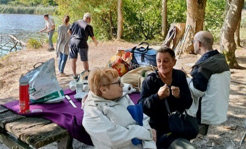 Personnes âgées qui font un pique nique au bord d'un lac