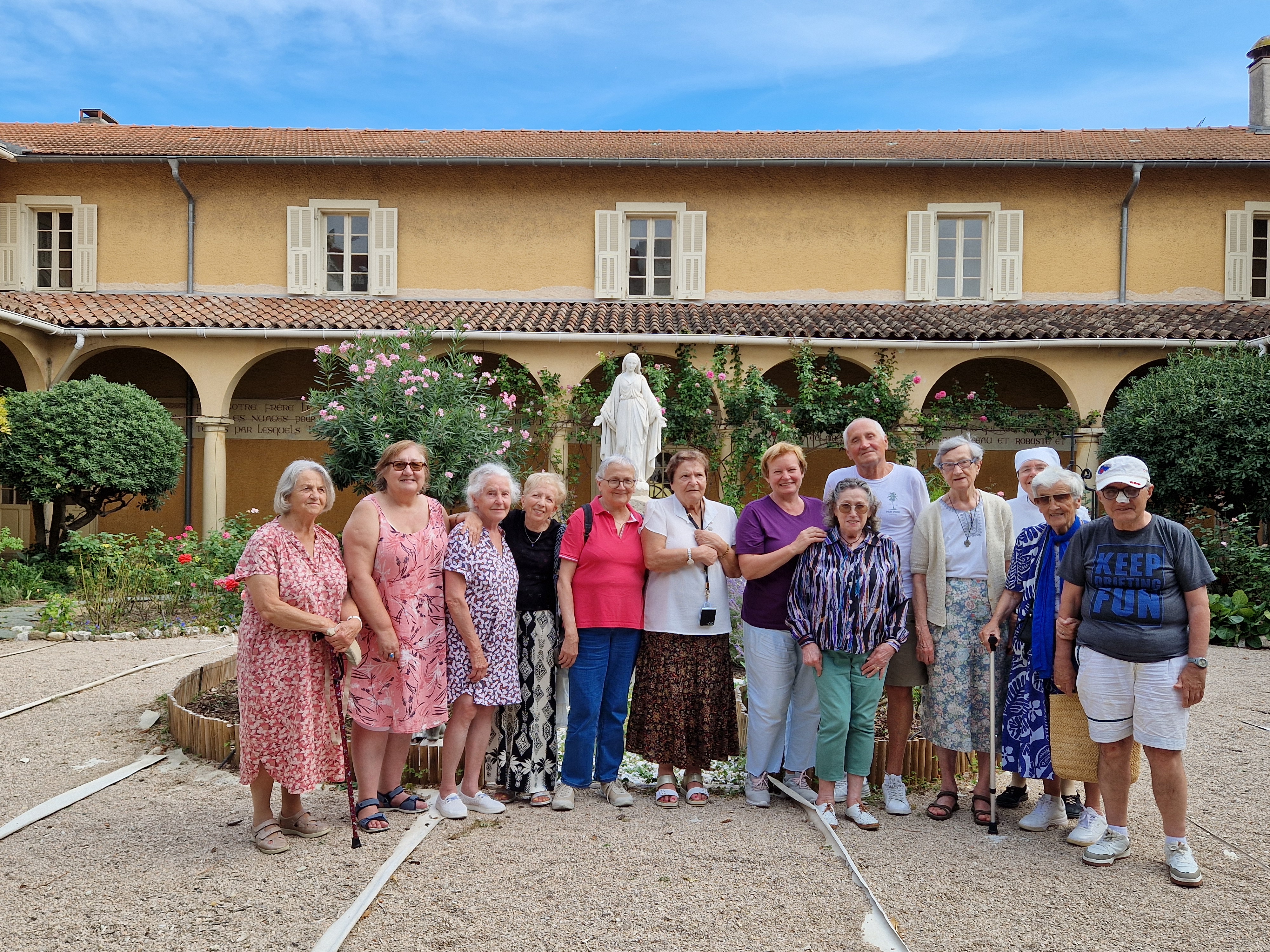 Personnes âgées devant une statue de Sainte Jeanne Jugan