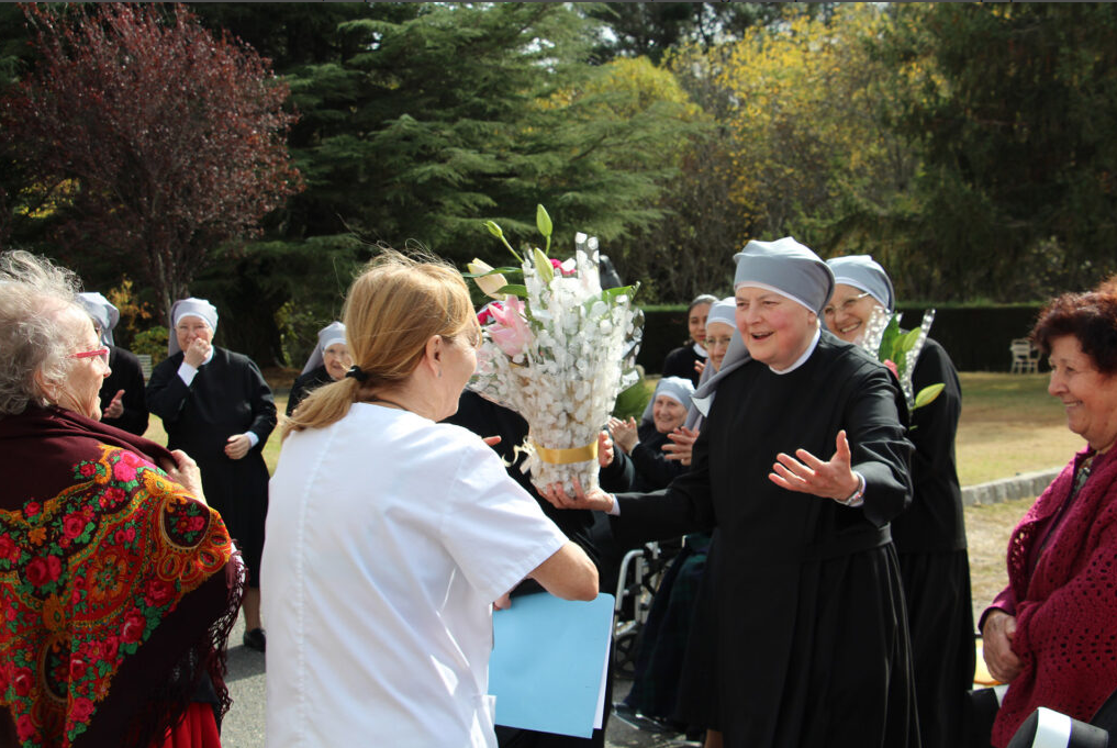 Petite soeur avec un bouquet de fleur donné par une salarié