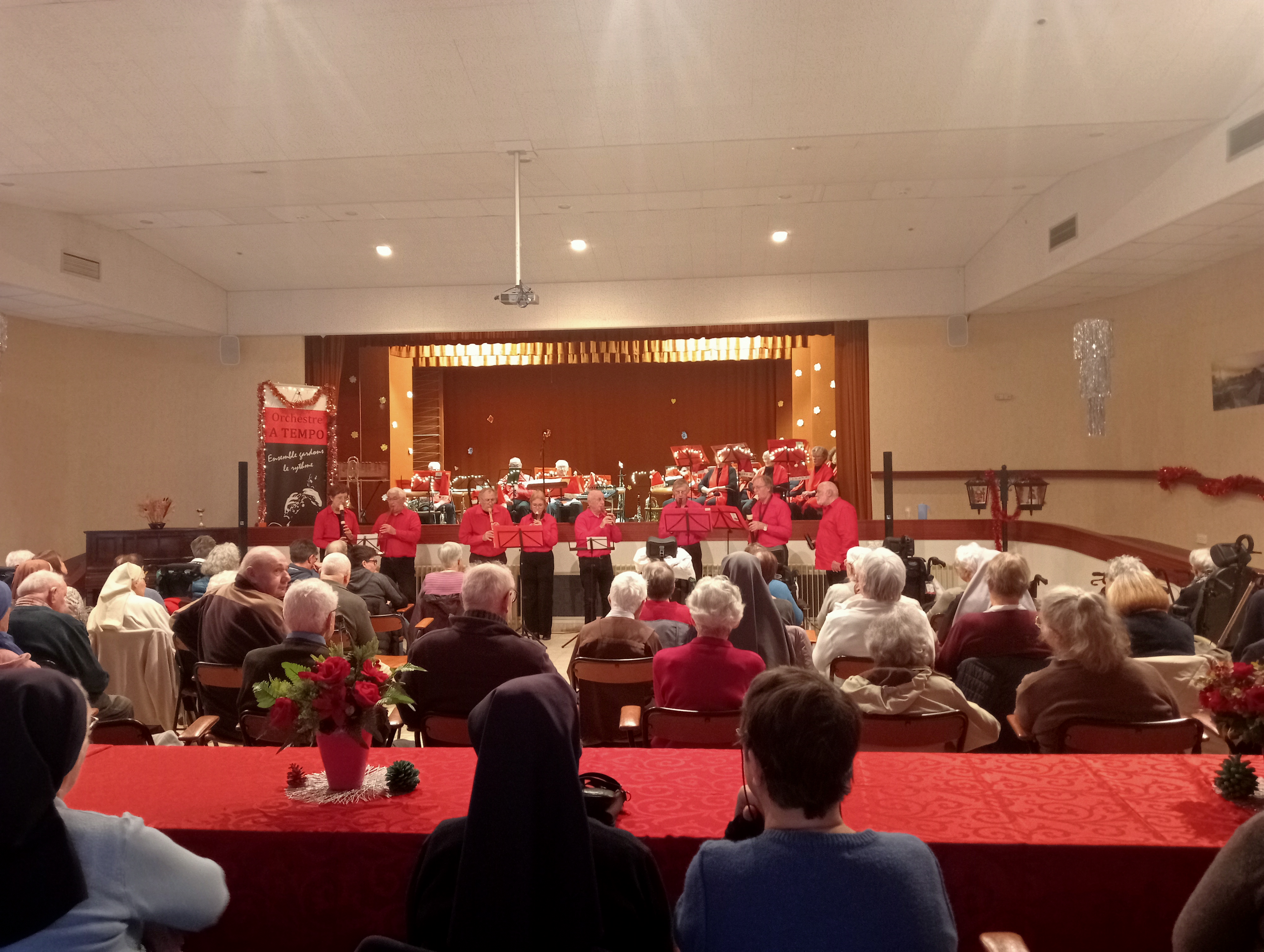 Personnes âgées dans un pièce devant un concert de Noël