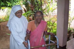 Petite soeur aidant une personne âgée à marcher, en Inde