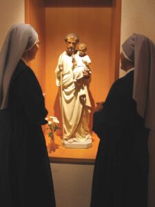 deux petites soeurs en prière auprès de la statue de St Joseph
