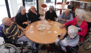 Résidents et Petites Soeurs jouant au cartes