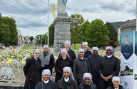 Rencontre de petites sœurs des pauvres à Lourdes devant une statue de Notre dame