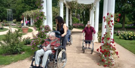 Personnes âgées qui se promènent dans un parc en fleurs