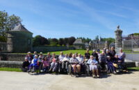 Personnes âgées devant un château avec des petites sœurs des pauvres au soleil