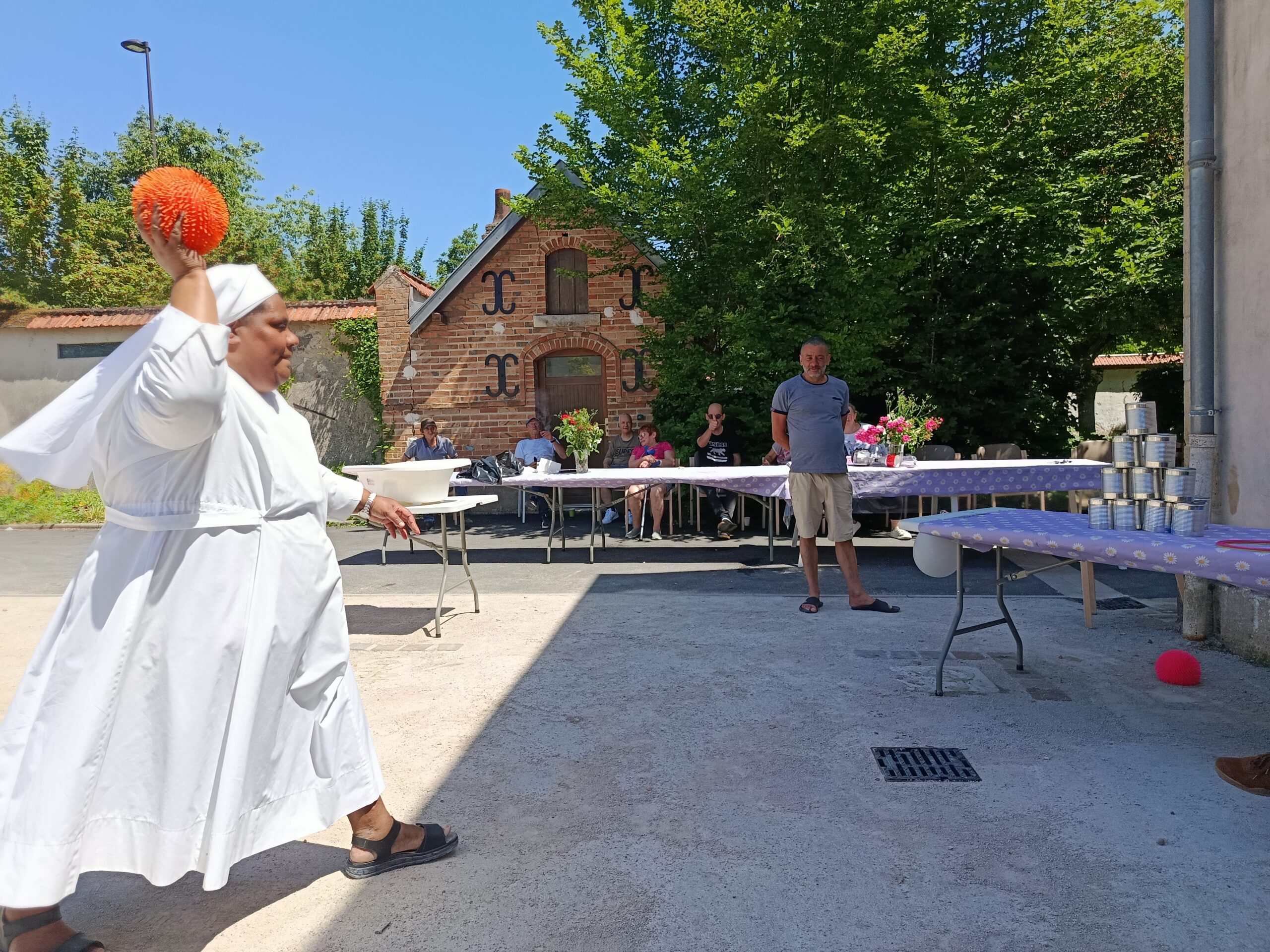 Petite soeur des pauvres qui lance un ballon