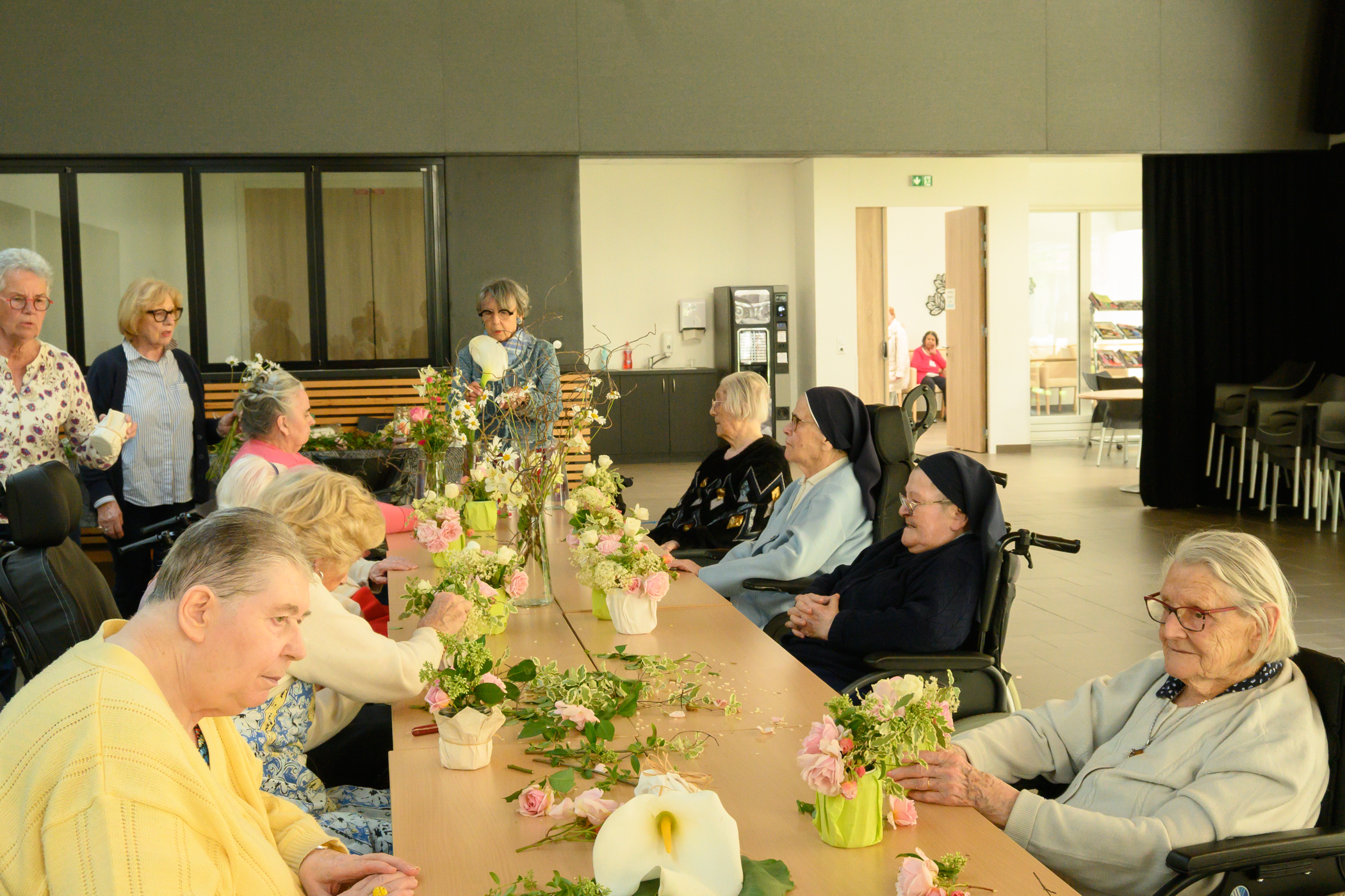 Personnes âgées pauvres qui font un atelier floral avec des petites soeurs des Pauvres