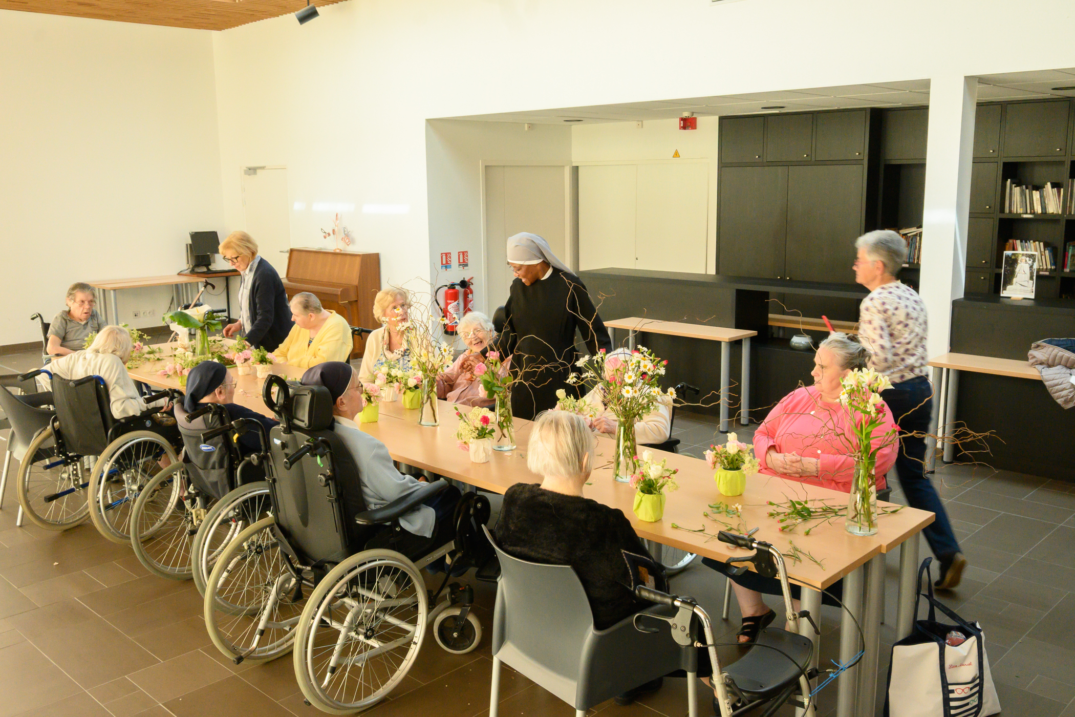 Personnes âgées pauvres qui font un atelier floral avec des petites soeurs des Pauvres