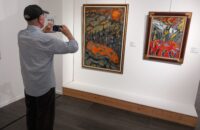 Personne âgée dans un musée qui regarde un tableau dans un musée
